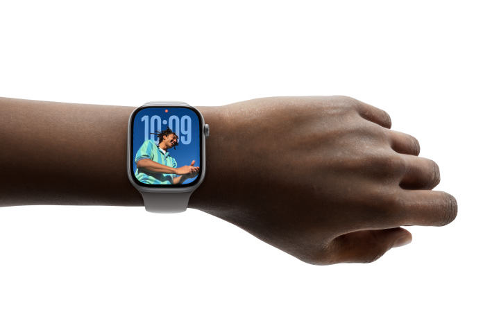 En person har på seg Apple Watch Series 11 med Bilder-urskiven