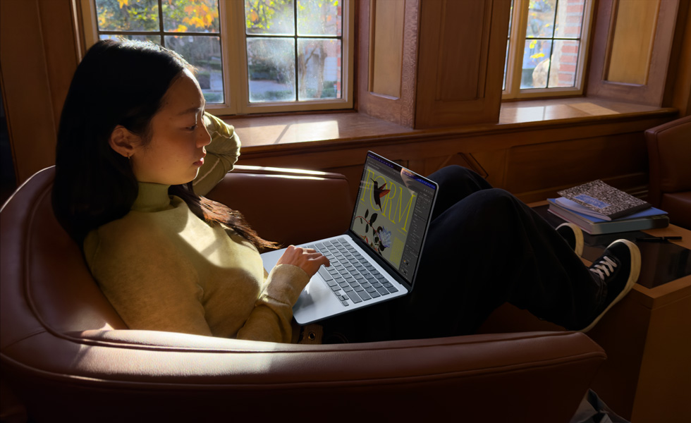 Osoba siedząca na krześle i korzystająca z MacBooka Air